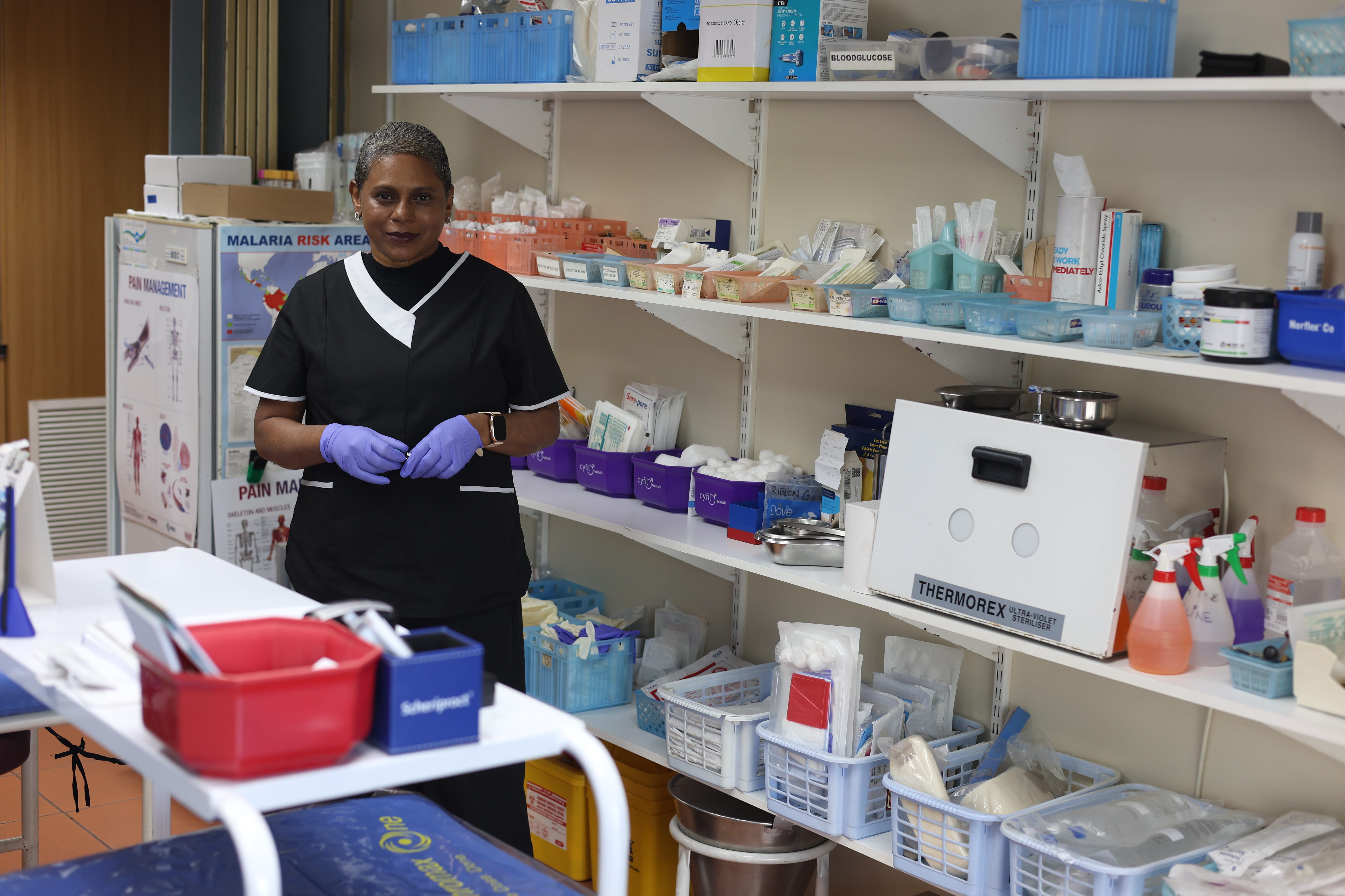 A member of the Sunningdale Medical Centre team among the treatment room shelves