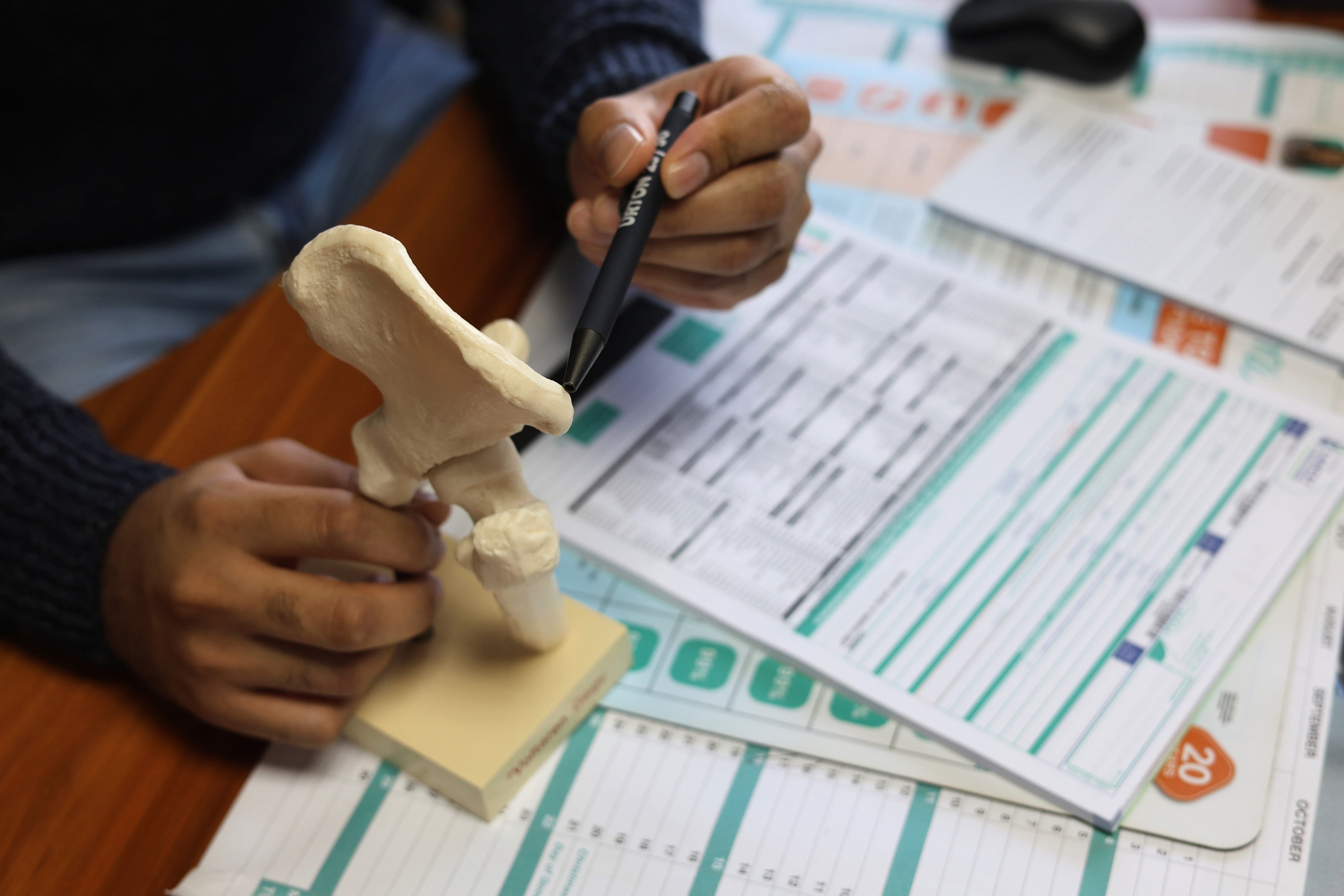 A doctor at Sunningdale Medical Centre explaining a diagnosis using an anatomical model