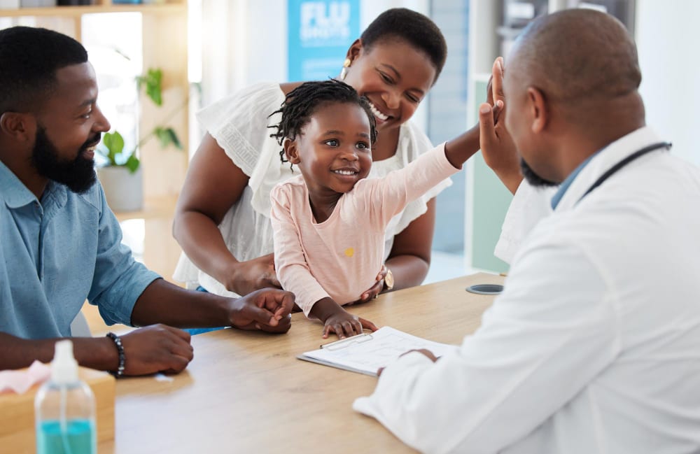 A family smiling with their doctor during a consultation