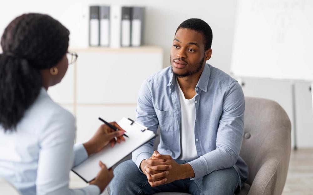A psychologist taking notes during a conversation with a patient